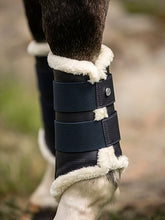 Load image into Gallery viewer, Brushing boots with elastic velcro fastening straps. The boots have a vegan leather surface and a padded patch on the inside for protection, and are fully lined with white faux fur. Front legs have two fastening straps and hind legs have three – all with one PS logo stud. 4-pack.
