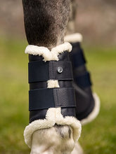 Load image into Gallery viewer, Brushing boots with elastic velcro fastening straps. The boots have a vegan leather surface and a padded patch on the inside for protection, and are fully lined with white faux fur. Front legs have two fastening straps and hind legs have three – all with one PS logo stud. 4-pack.
