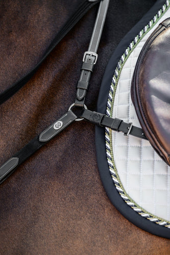 A well-worked breastplate, extra padded along the withers for additional comfort. The martingale is adjustable on both sides of the neck. The clever Snap It hooks make it unnecessary to open the reins to connect the equipment which is great both out of a practical and safety point of view.