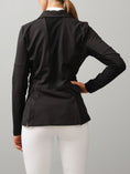 Load image into Gallery viewer, High function, tailored competition blazer made in a technical, stretchy material with a perfect fit. Button closing at the front and a hidden zipper underneath. Pockets at sides with hidden, discreet zippers. Double mesh (non-see through) on the back, sides and under arms for optimal ventilation. Design details such as shiny lining inside peplum and tonal logo on left sleeve.
